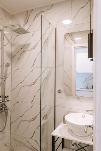 a bathroom with a sink and a shower at Sithon Diamond Suites 2 in Nikiti