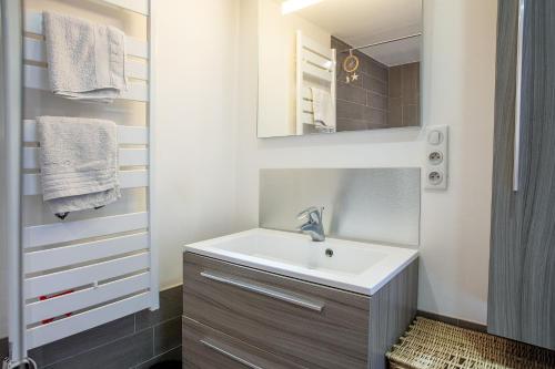 een badkamer met een wastafel en een spiegel bij Le Mazet des Olivades in Plan-de-la-Tour
