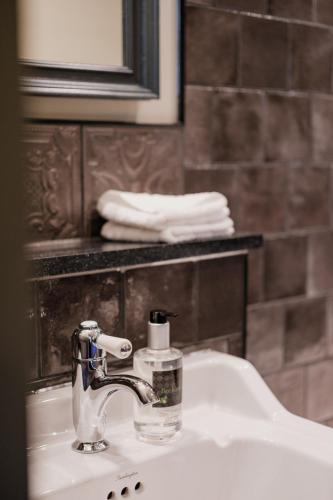 a bathroom sink with a faucet and a mirror at The Sanctuary House Hotel in London