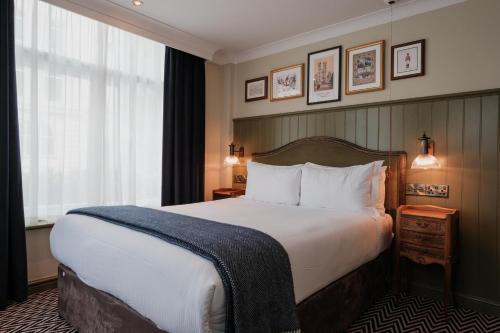 a hotel room with a large bed and a window at The Sanctuary House Hotel in London