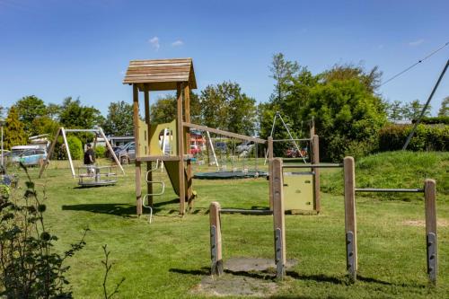 a park with a playground with a swing set at Chalet 539 op Recreatiepark De Wielen in Sint Maarten