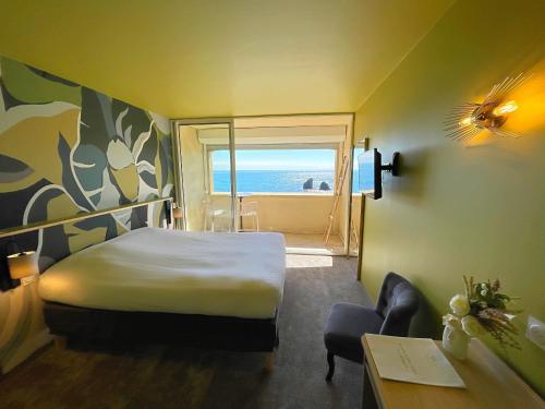 a bedroom with a bed and a window with the ocean at Hôtel La Grande Conque in Cap d'Agde