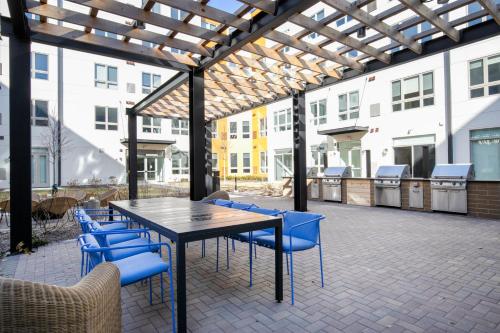 a patio with a wooden table and blue chairs at Arlington Heights 2br w wd gym bbq nr dining CHI-911 in Arlington Heights
