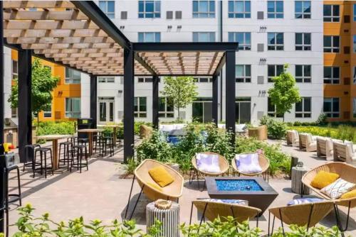 an outdoor patio with chairs and tables and a pergola at Arlington Heights 2br w wd gym bbq nr dining CHI-911 in Arlington Heights