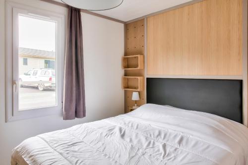 ein Schlafzimmer mit einem weißen Bett und einem Fenster in der Unterkunft Escapade entre ocean et foret a Pont-l Abbe in Pont-lʼAbbé