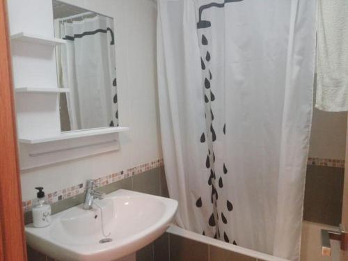 łazienka z umywalką i zasłoną prysznicową w obiekcie Apartamento El Diario w mieście Adra