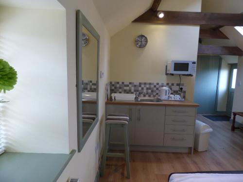a kitchen with a sink and a counter with a stool at Cosy Studio Cottage in Lincoln