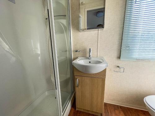 a small bathroom with a sink and a shower at Brilliant 8 Berth Caravan With Decking At Haven Caister Beach Ref 30055p in Great Yarmouth