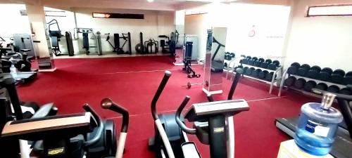 un gimnasio con suelo rojo y filas de máquinas en Juba Landmark Hotel, en Yuba