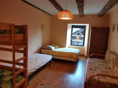 une chambre avec deux lits superposés et une fenêtre dans l'établissement Gites grande capacité à saint-chély-d’aubrac, à Regaussou