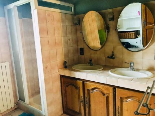 une salle de bain avec deux lavabos et un miroir dans l'établissement Gites grande capacité à saint-chély-d’aubrac, à Regaussou