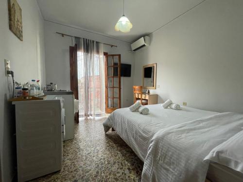 1 dormitorio con 1 cama blanca y cocina en The Beehive 2 en Mitilene