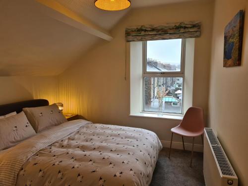 a bedroom with a bed and a window at Heart of Windermere in Windermere