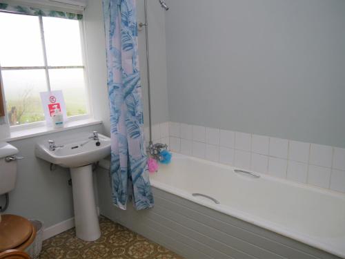 a bathroom with a sink and a bath tub and a sink at The Drovers Cabin in Kirkcudbright