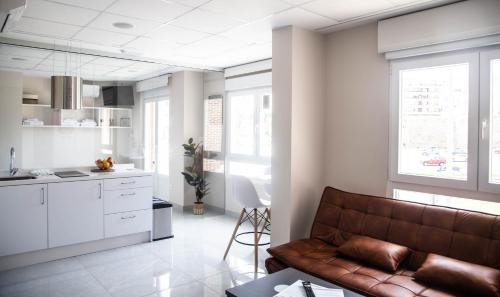 uma sala de estar com um sofá e uma cozinha em Astorga suites em Astorga