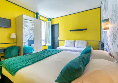 ein Schlafzimmer mit einem großen Bett mit gelben Wänden in der Unterkunft Nouvel Hôtel in Paris