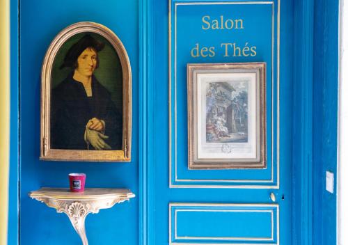 a blue door with a painting of a woman and a table at Nouvel Hôtel in Paris