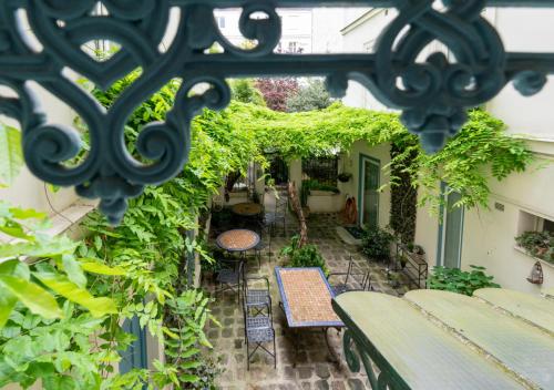 an outdoor patio with tables and chairs and plants at Nouvel Hôtel in Paris