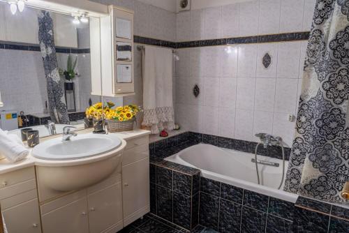 un bagno con vasca, lavandino e vasca da bagno di Estell’s sweet luxury house a Volos