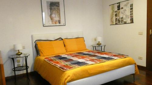 ein Schlafzimmer mit einem Bett mit orangefarbenen Kissen in der Unterkunft Mamma Mia on ground floor with private parking TV-VENICE in Treviso