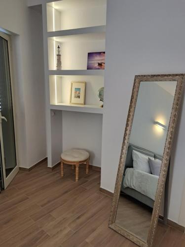 a mirror in a room with a bed and a stool at M. Szwed. Guest House old Bari in Bari