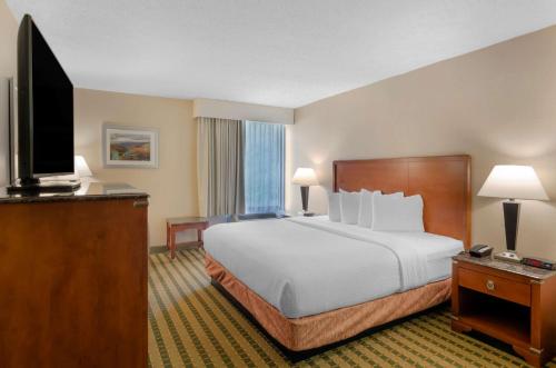 a hotel room with a bed and a flat screen tv at Best Western North Roanoke in Troutville