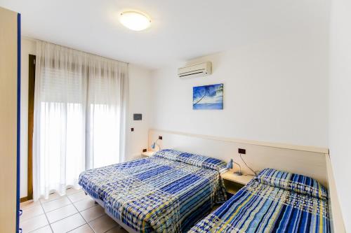 a bedroom with two beds and a window at Ginepri Lido Altanea in Caorle