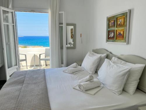 a bedroom with a white bed with a view of the ocean at Vavanos Studios in Naousa