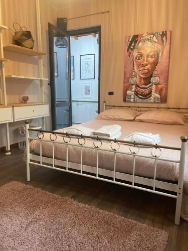 ein Schlafzimmer mit einem Bett mit einem Bild einer Frau in der Unterkunft Casa sole in Stresa
