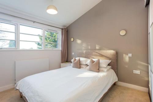 a bedroom with a large white bed with pillows at Family home close to Bournemouth town centre in Bournemouth