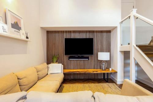 a living room with a couch and a flat screen tv at Family home close to Bournemouth town centre in Bournemouth