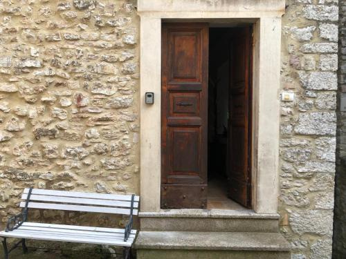 a bench sitting in front of a building with a door at La casetta in Ferentillo