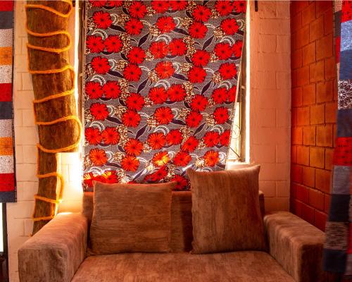 a couch in front of a wall with red flowers at Meleji Studio House in Arusha