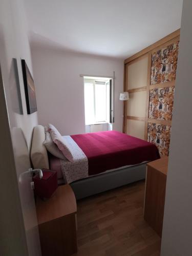 a bedroom with a bed with a red blanket and a window at Mary's House in Rome