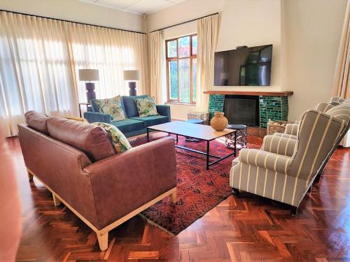a living room with two couches and a fireplace at Hydrangea Guest House in Nottingham Road