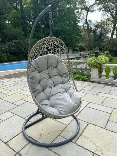 a swinging chair sitting on a patio at Maywoods Apartment in Virginia Water
