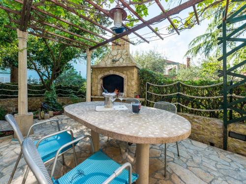 a patio with a table and chairs and a stone fireplace at Green Terrace Apartment I in Dubrovnik