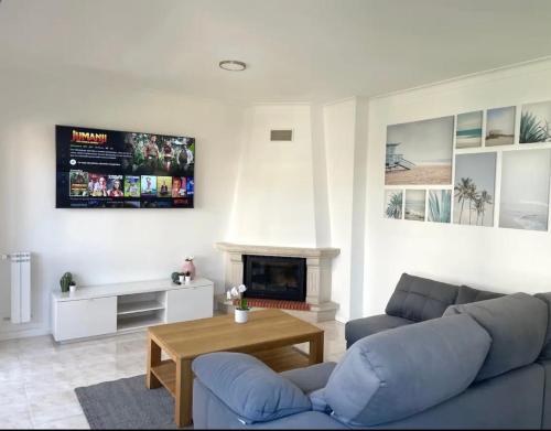 a living room with a blue couch and a fireplace at Apartamento Feliz in Figueira da Foz