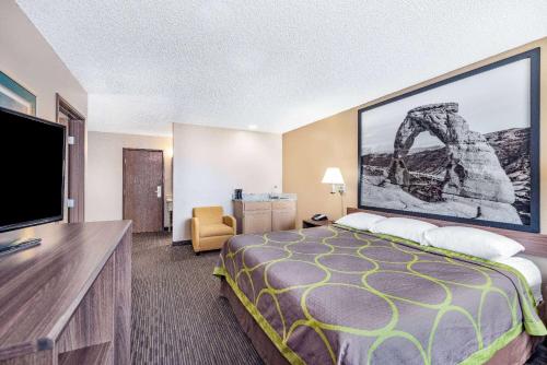 a hotel room with a bed and a flat screen tv at Super 8 by Wyndham Richfield UT in Richfield