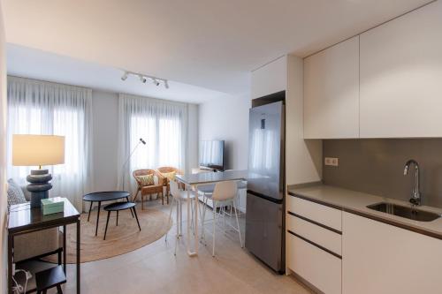 a kitchen with white cabinets and a table and chairs at NEW Stylish 2 Bedroom Apt in Las Palmas de Gran Canaria