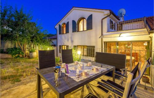 una mesa de comedor frente a una casa en Nice Home In Ruzici With 3 Bedrooms, Wifi And Outdoor Swimming Pool, en Ružići