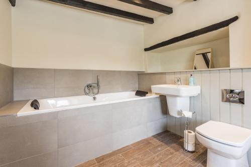 a bathroom with a tub and a toilet and a sink at The Hopton Crown in Cleobury Mortimer