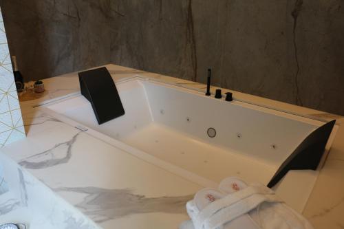 una vasca da bagno bianca seduta in bagno di Albergo Del Sedile a Matera