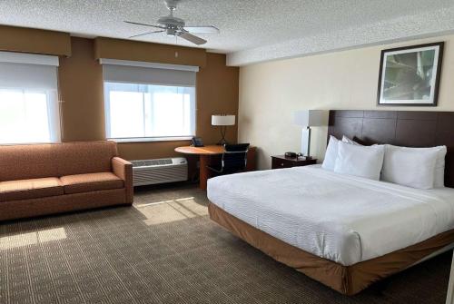 um quarto de hotel com uma cama e uma cadeira em La Quinta by Wyndham Orlando South em Orlando