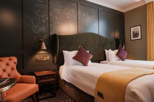 een hotelkamer met 2 bedden en een stoel bij The Sanctuary House Hotel in Londen