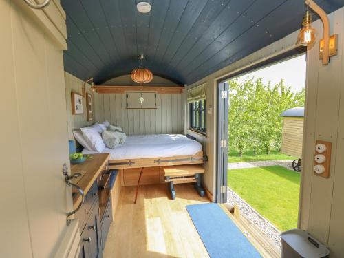 1 dormitorio en una casa pequeña con cama y escritorio en Merlot, en Seaview