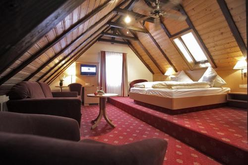 a bedroom with a bed and chairs in a attic at Gasthof Hirsch in Gengenbach