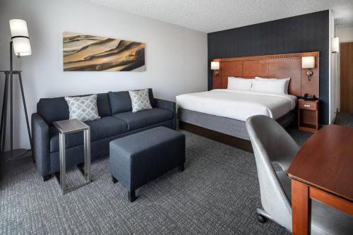 a hotel room with a bed and a couch at Courtyard Sacramento Rancho Cordova in Rancho Cordova