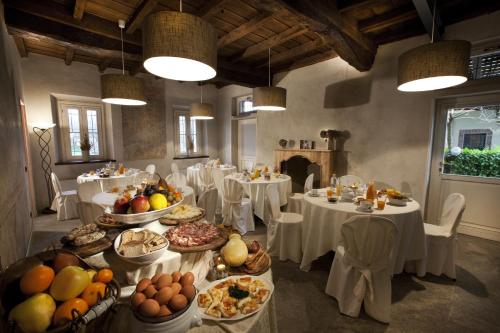 une grande salle à manger avec des tables et des assiettes de nourriture dans l'établissement Hotel Morimondo, à Morimondo