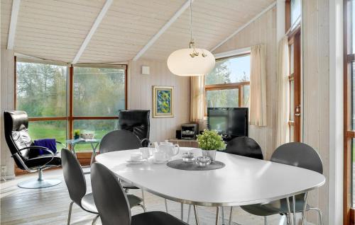 a dining room with a white table and chairs at Holiday Home Baldersvej Askeby Ix in Askeby